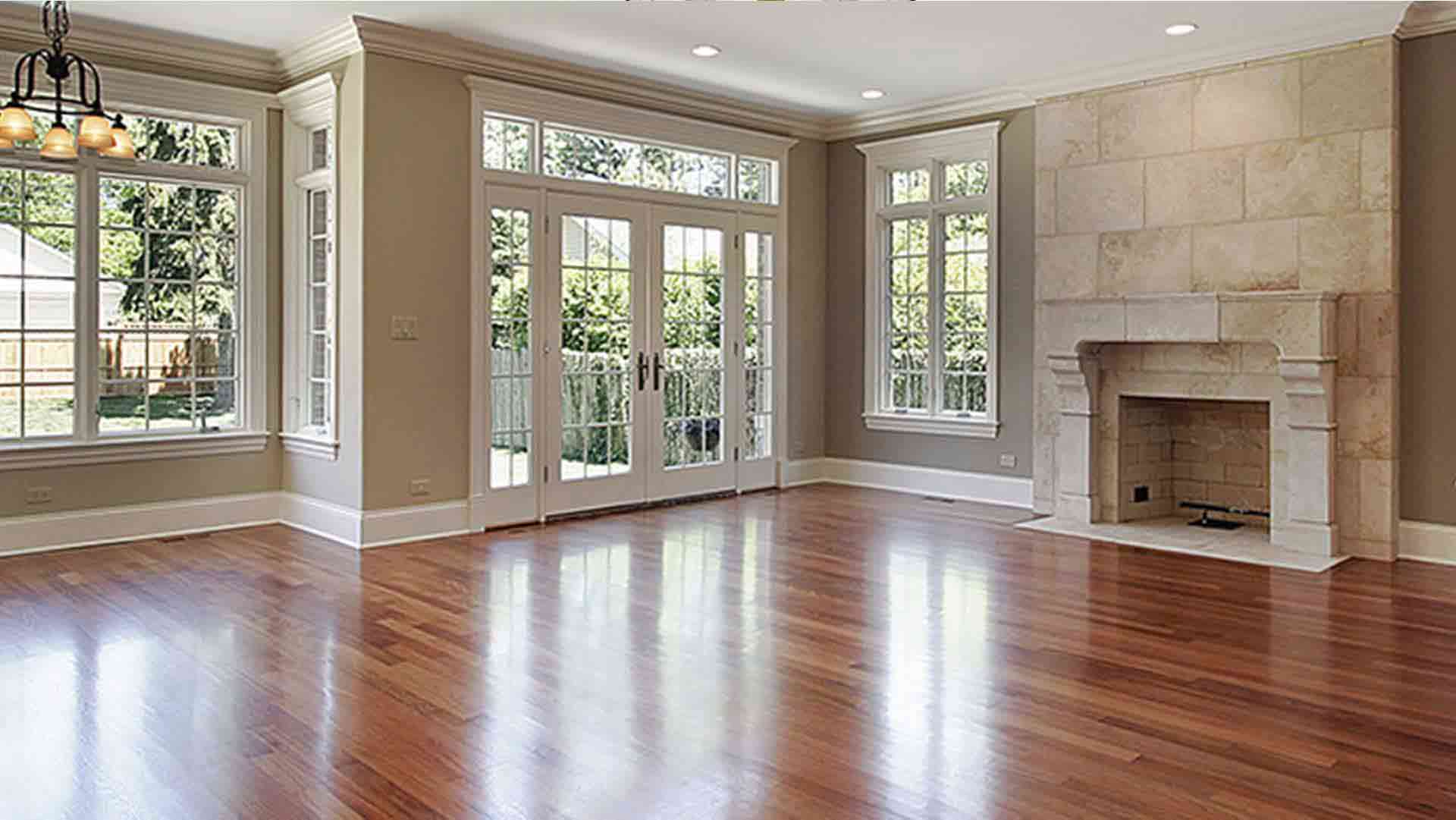 Beautiful living room with cherry hardwood floors, stone fireplace, and floor-to-ceiling windows flooding with natural light